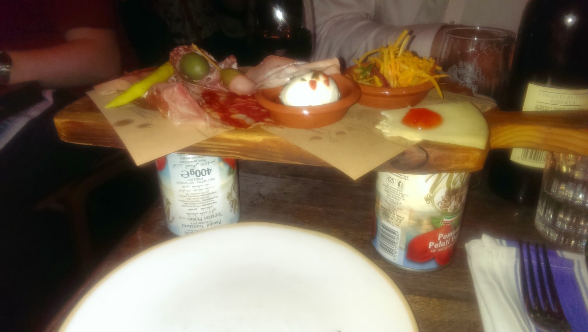 Cheese board sitting on cans of tomatoes